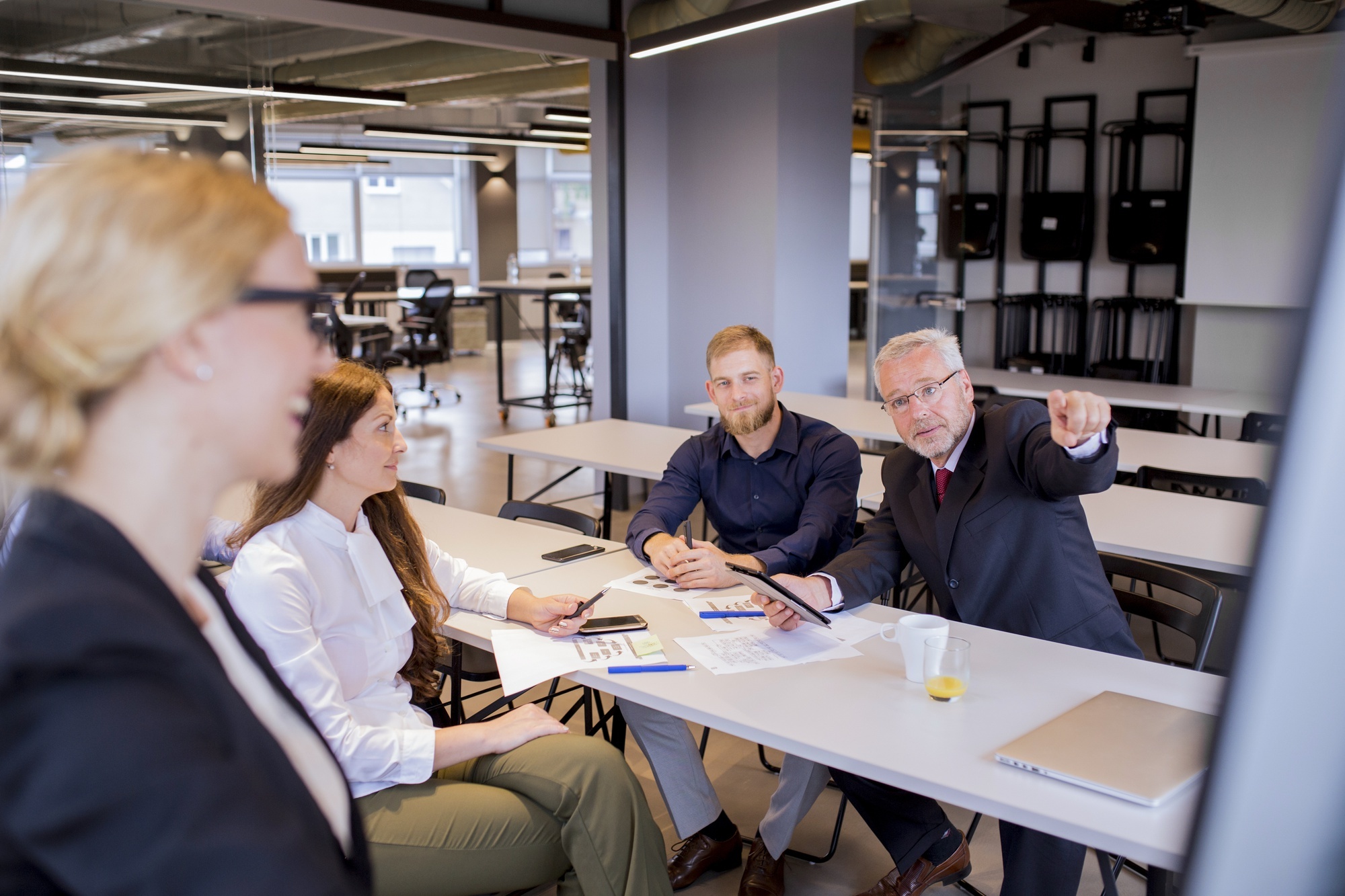 curious-mature-businessman-pointing-finger-flip-chart-presentation
